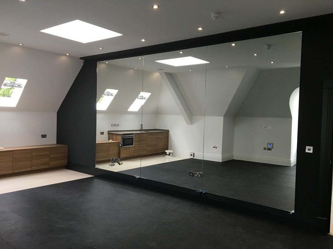 Frameless glass wall dividing loft conversion in Banbury